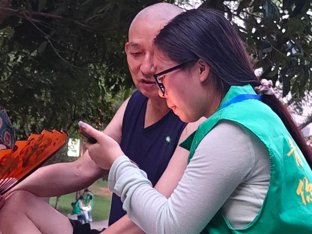 圖為老人向志愿者展示數字化操作。潘薇供圖